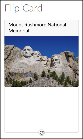 A screenshot of the DesignPLUS "Flip Cards" tool in use on a Canvas LMS course page, displaying the front side of a single flip card. Above the card, the large, light grey text heading reads "Flip Card". The card itself, outlined in light grey, features the bold text "Mount Rushmore National Memorial" at the top. Below this text is a clear photograph of the four presidential faces carved into the mountain rock against a vivid blue sky, with a dark green pine forest visible at the base of the carvings. At the bottom center of the card, a circular icon containing two counter-rotating arrows is displayed, indicating the card can be flipped.