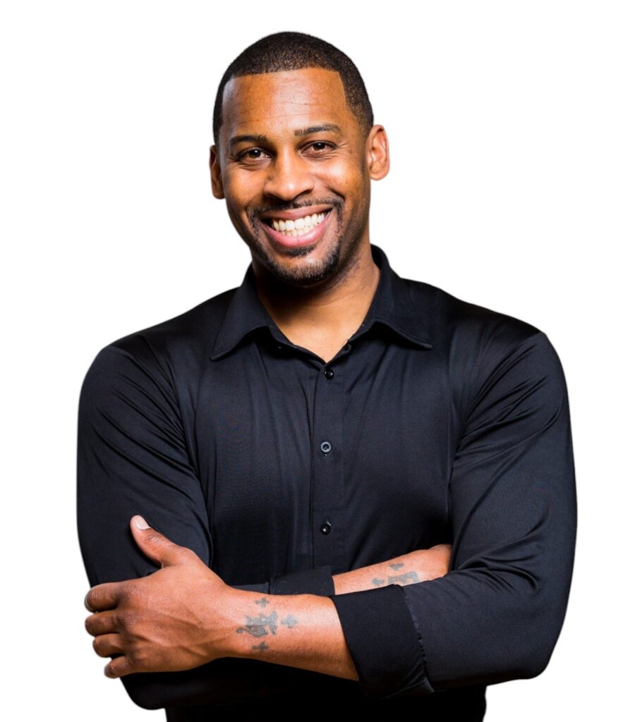 Headshot of Sherrad Glosson smiling with arms crossed, wearing a black button-up shirt